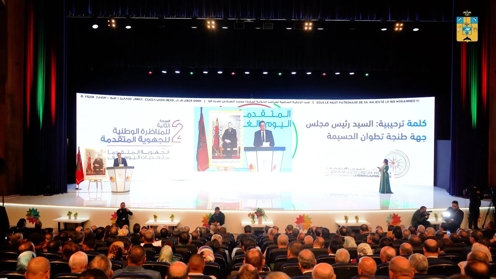 Speaker on the main stage of a national conference in Tangier, with a full auditorium