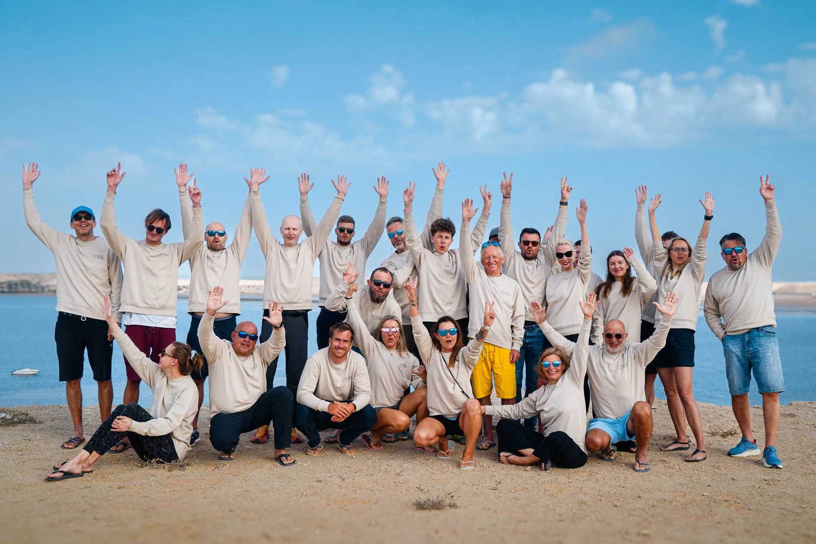 A kite camp group cheering together by the Dakhla lagoon