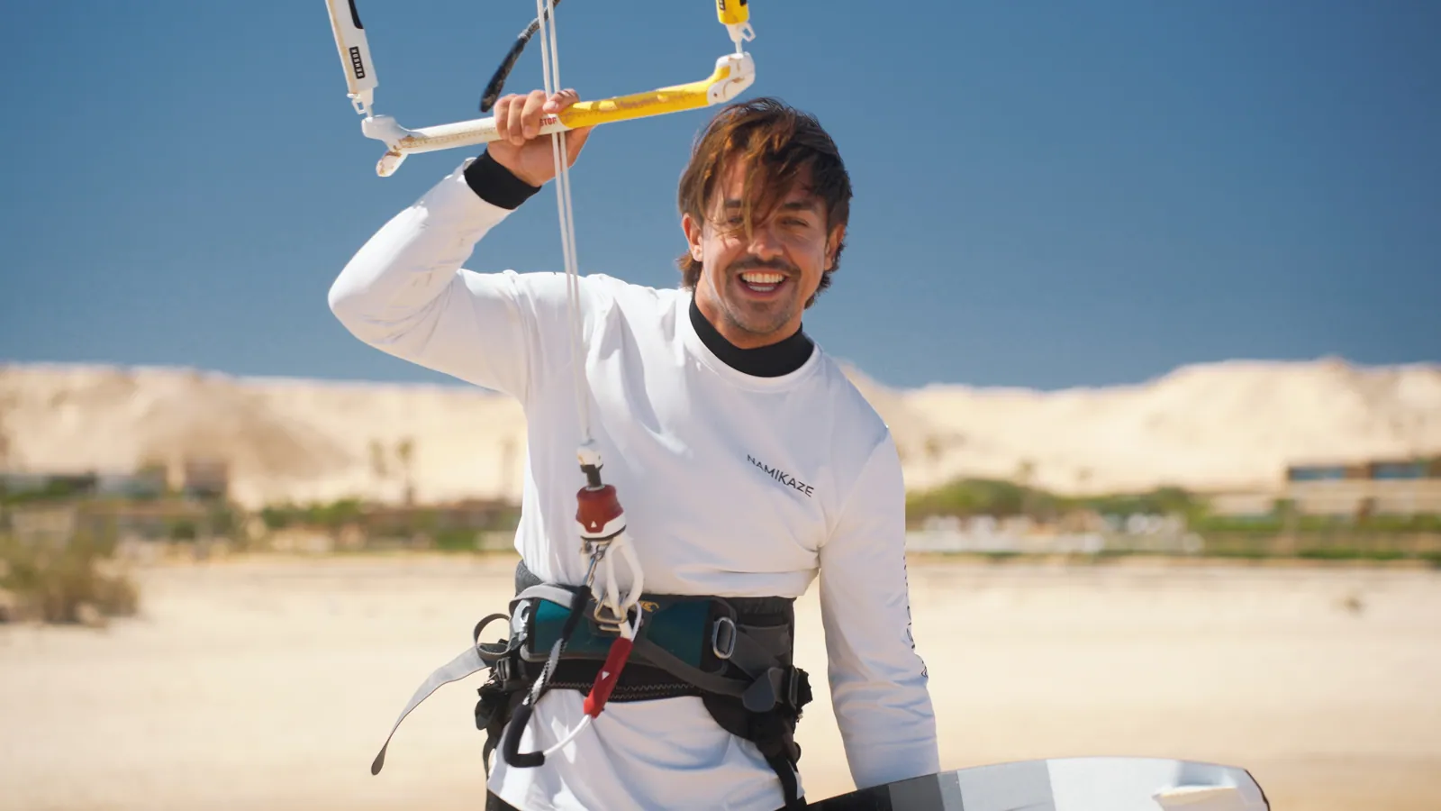 Smiling kitesurfer holding his bar on the beach in Dakhla