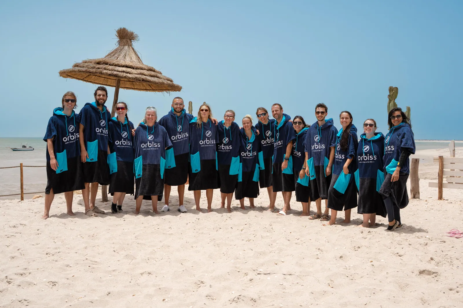 A team in matching beach ponchos on the sand in Dakhla