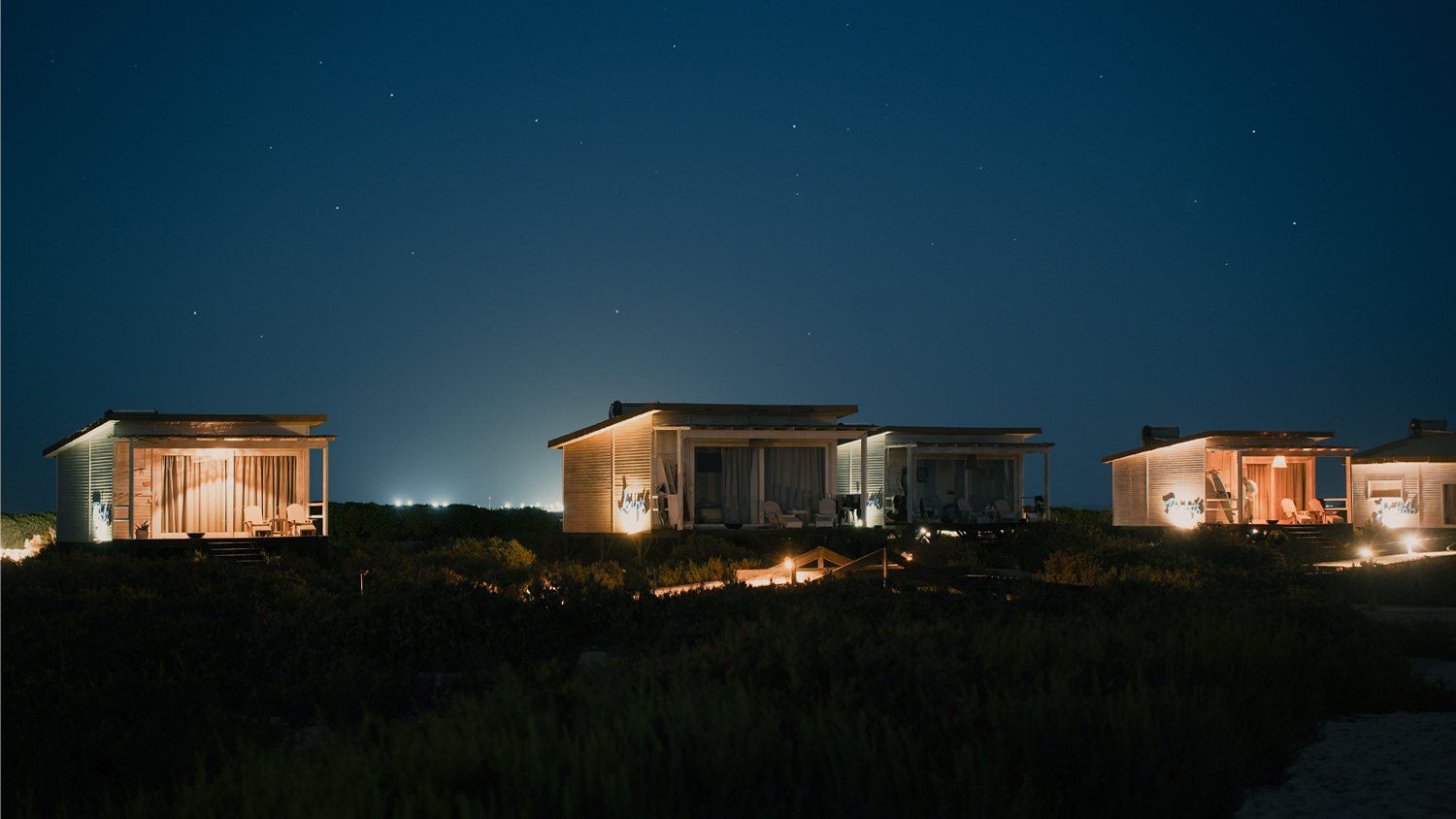 Beach bungalows lit up under the stars in Dakhla